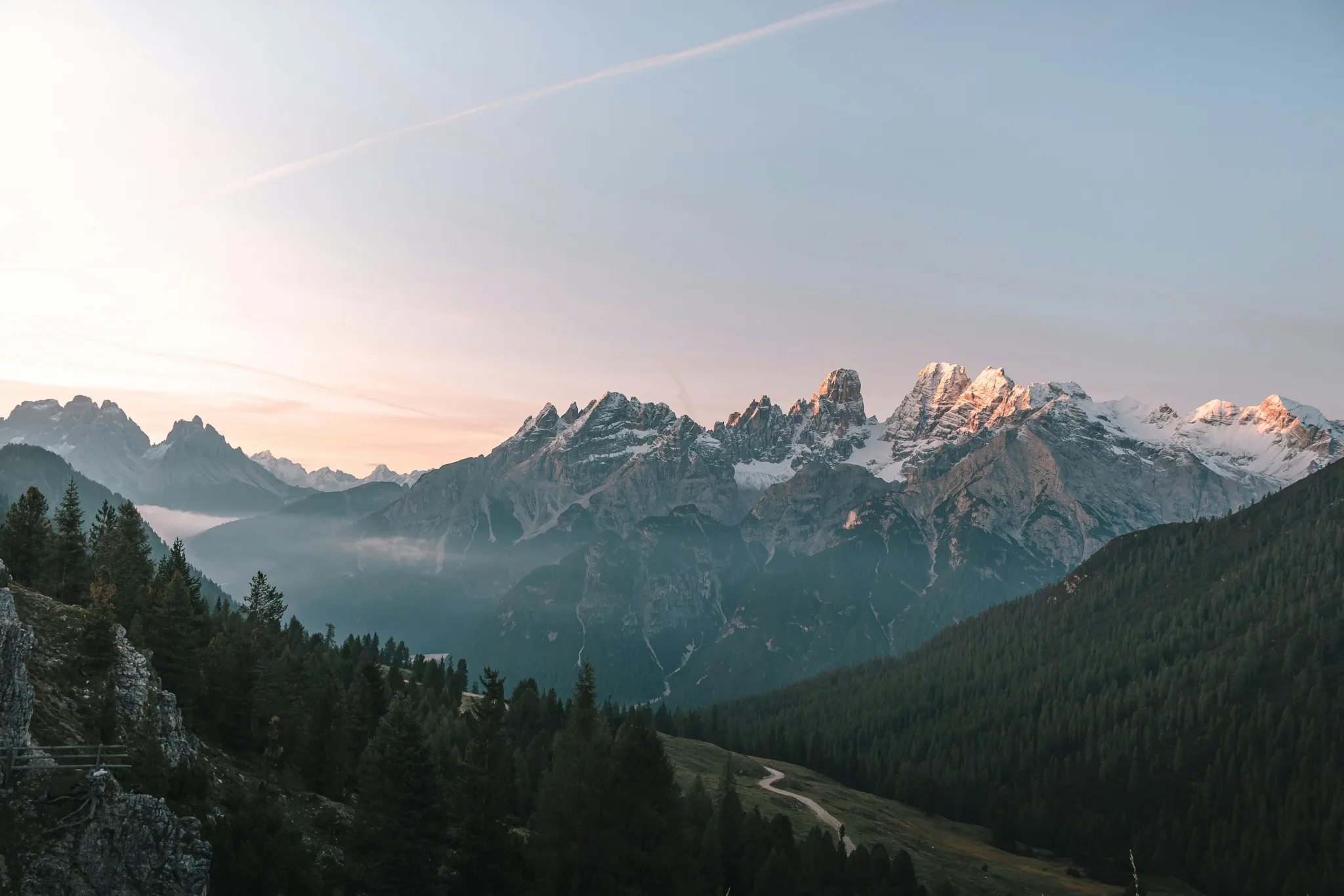 Sunlit alpine peaks beneath a pastel sky
